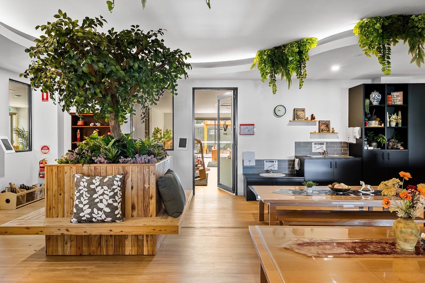 Bright play room with timber benches and planter at Treetop Early Learning, Epping